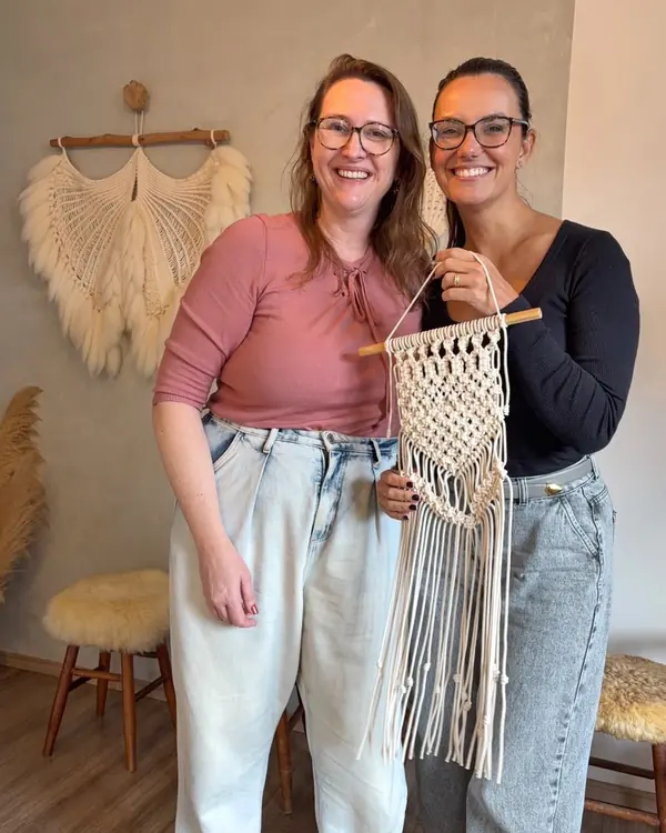 Márcia e uma aluna sorrindo com o painel pronto